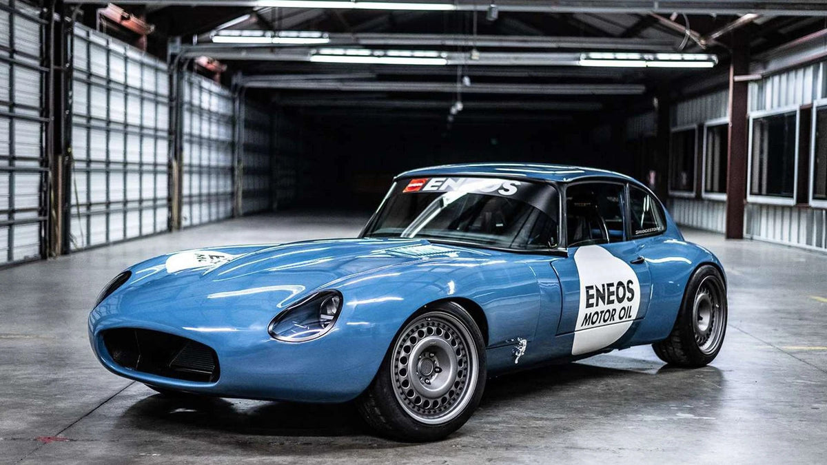 DevSpeed's 2JZ-swapped Jaguar E-Type in ENEOS livery, front three-quarter view in a warehouse, with our 3D printed fender flares