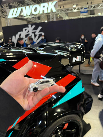 The MiniGT die-cast of the RS-01T held in front of the real car