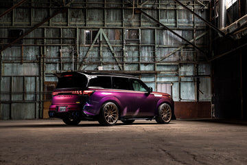 INFINITI QX80 R-Spec in a warehouse, rear three-quarter view